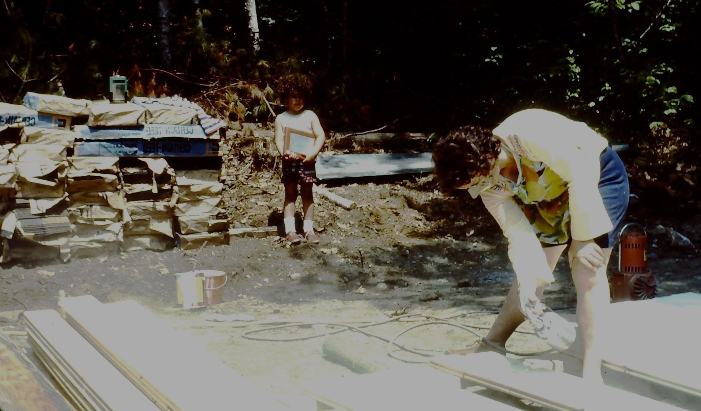 Maria supervising her mom who is staining ceiling boards